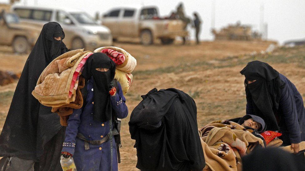 Women flee the last IS-held village in Syria, Baghuz, on 13 February 2019