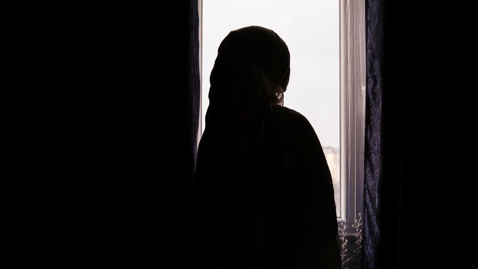 Woman silhouetted by a window