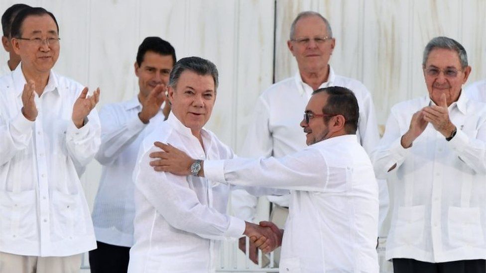 This file photo taken on September 26, 2016 shows Colombian President Juan Manuel Santos (L at centre) and the head of the FARC guerrilla Timoleon Jimenez, aka Timochenko, during the signing of the historic peace agreement between the Colombian government and the Revolutionary Armed Forces of Colombia (FARC), in Cartagena.