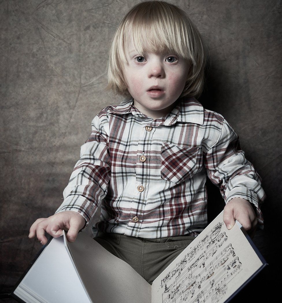 A young boy holds a book