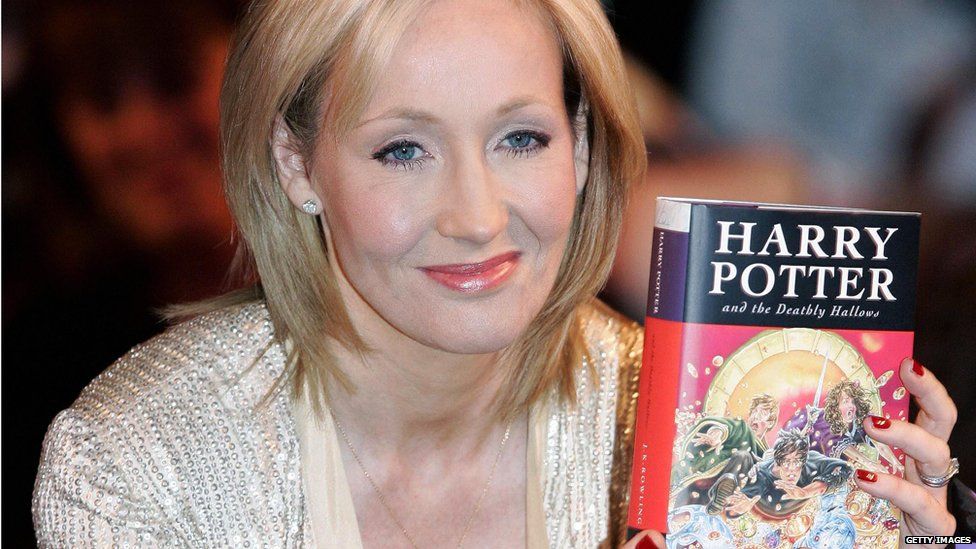JK Rowling with a copy of The Deathly Hallows