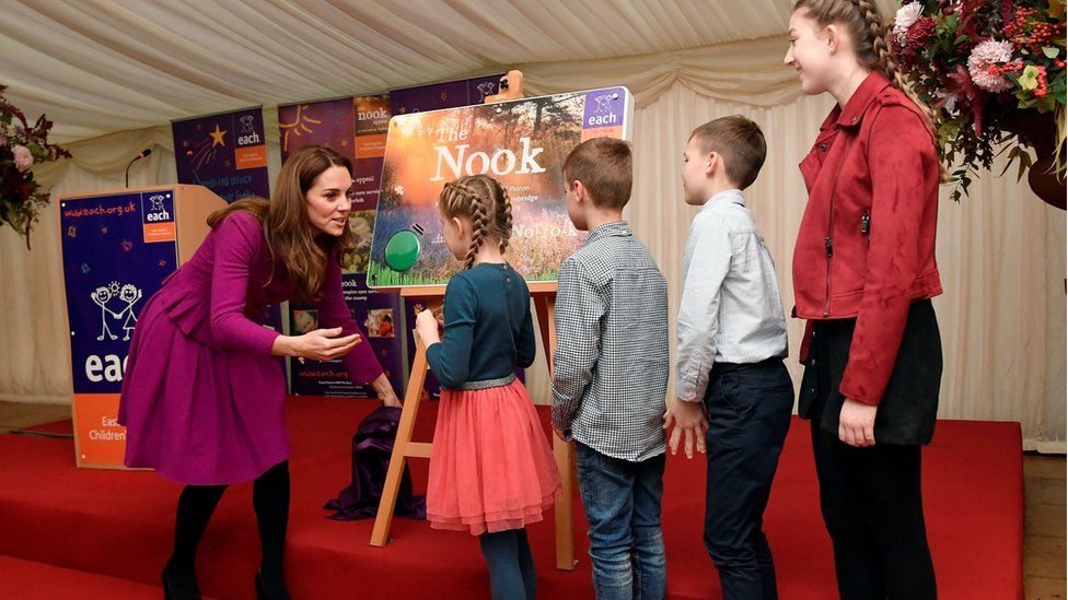 Four children help the Duchess of Cambridge unveil a plaque