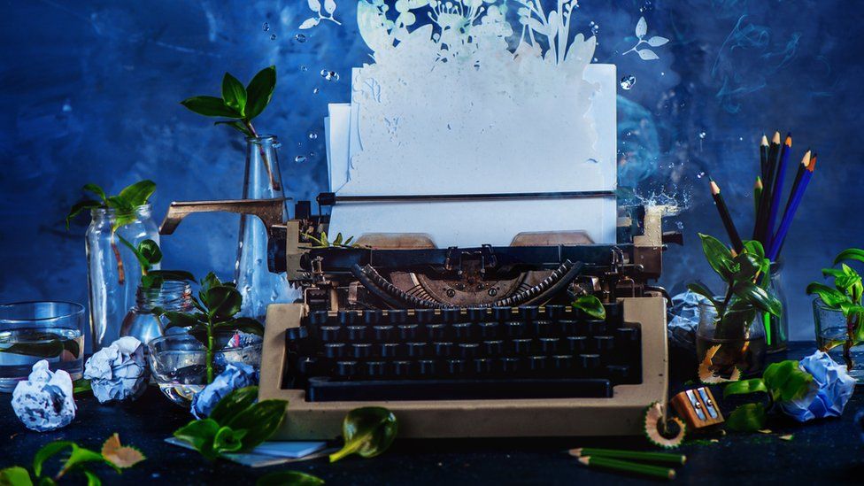 Creative picture of a typewriter surrounded by flowers
