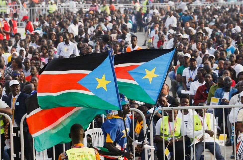 A large crowd with South Sudanese flags