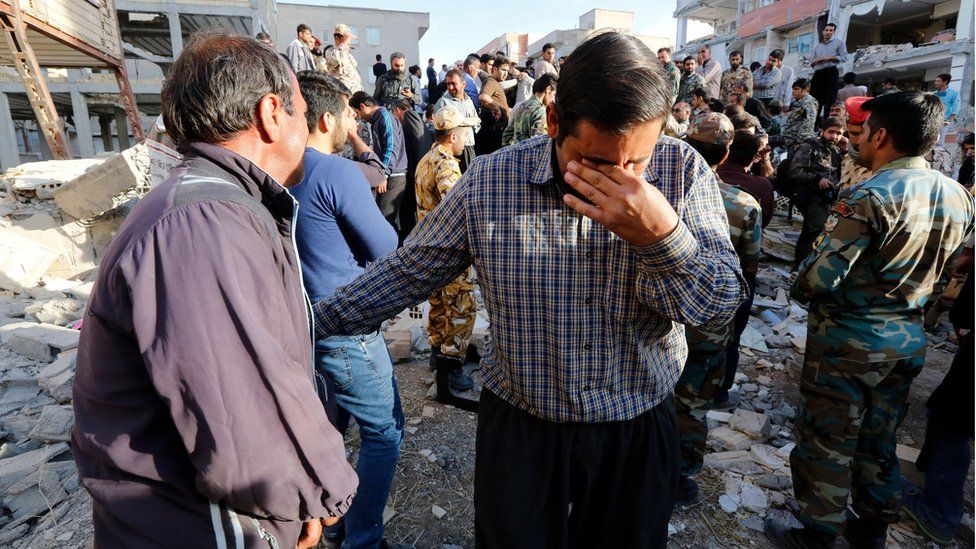 Iranian victims of the earthquake mourn near the wreckage of their home in the city of Pole-Zahab, in Kermanshah Province, Iran, 13 November 2017