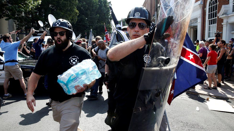 A far-right protester clutches a black shield