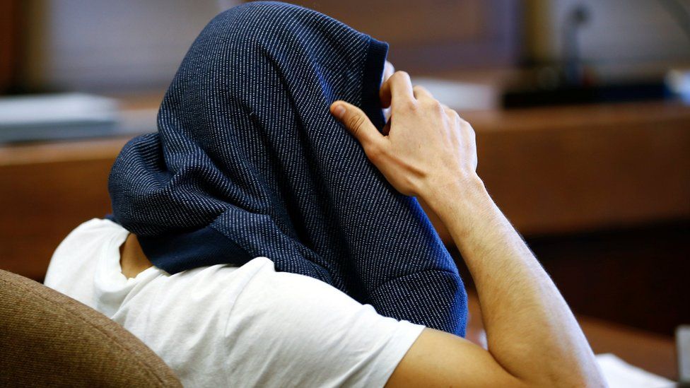 A 26-year-old Algerian who faces charges of assaults on woman during New Year's Eve celebrations in Cologne, covers his head at a regional court in Cologne, western Germany, May 6, 2016