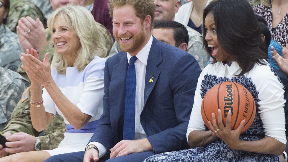 US First Lady Michelle Obama reacts to catching a basketball alongside Britain's Prince Harry and Jill Biden, wife of the US Vice President, as they attend a Wounded Warriors wheelchair basketball game at Fort Belvoir, Virginia, October 28, 2015