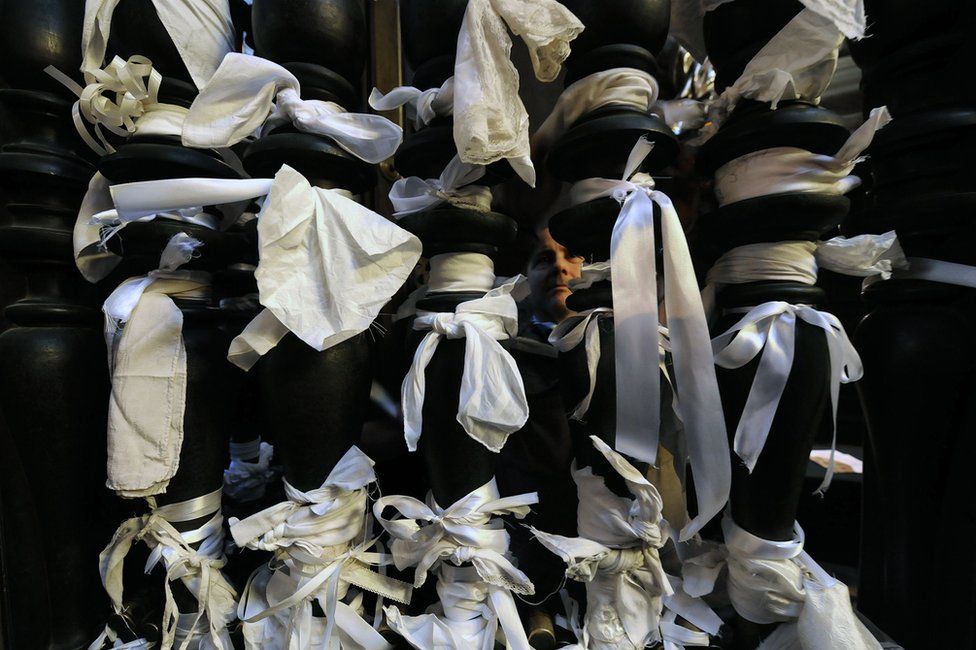 White ribbons tied to pillars on the gate of the San Gennaro chapel inside the cathedral of Naples, 5 March