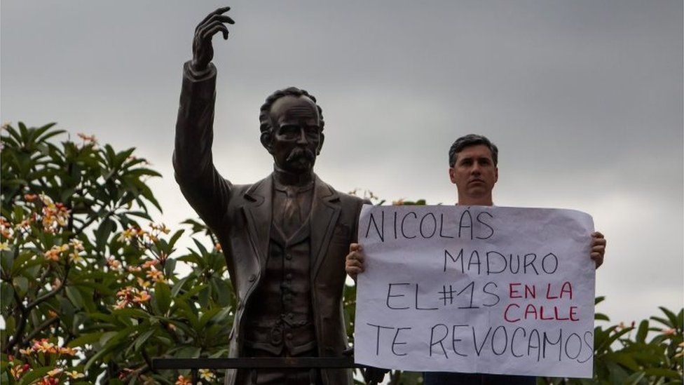 A supporter of the Venezuelan opposition holds a banner reading "Nicolas Maduro the 1st of September we will revoke you in the street" as they demonstrate in Caracas, Venezuela, 19 August 2016.