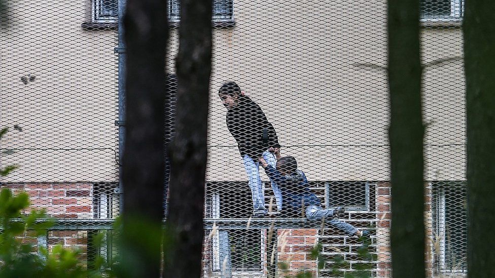 Migrant children play at a detention facility surrounded by a barbed wire fence in the Czech Republic