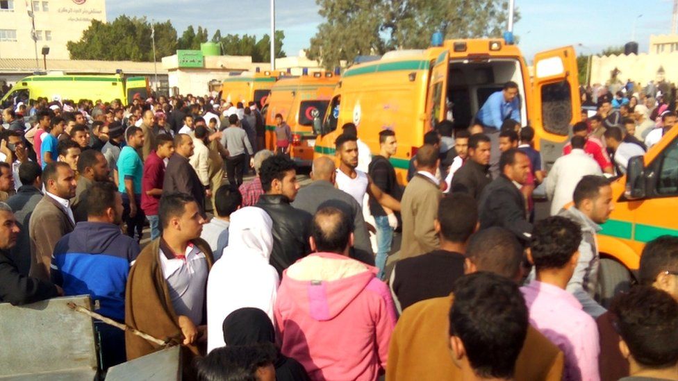 People gather around ambulances after the attack at the Rawda mosque on 24 November