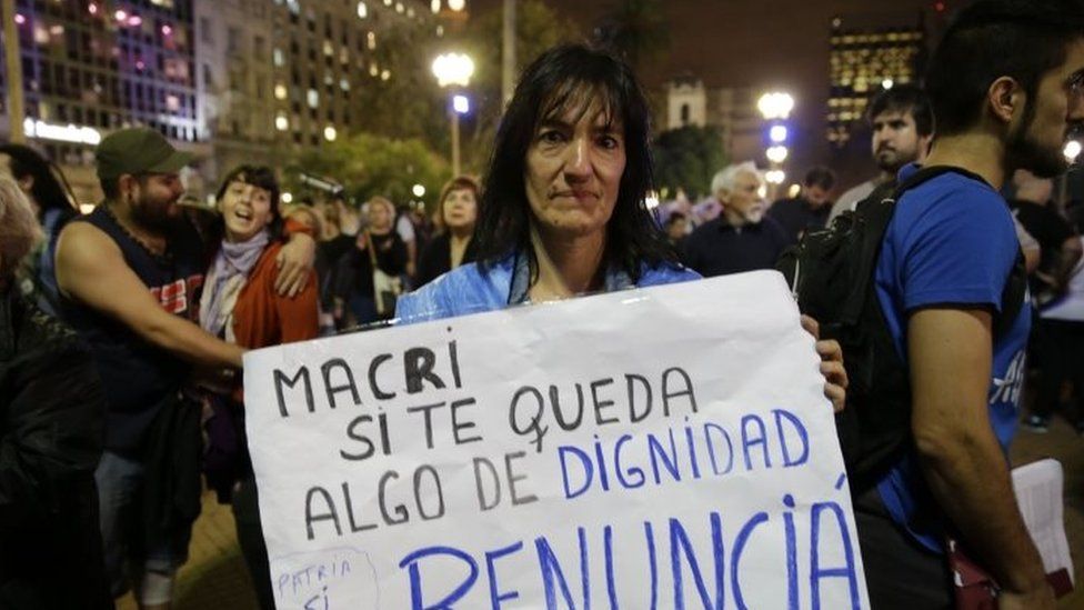 A woman holds a sign that reads in Spanish "Macri if you have any dignity, resign" during a protest against President Mauricio Macri n Buenos Aires (07 April 2016)