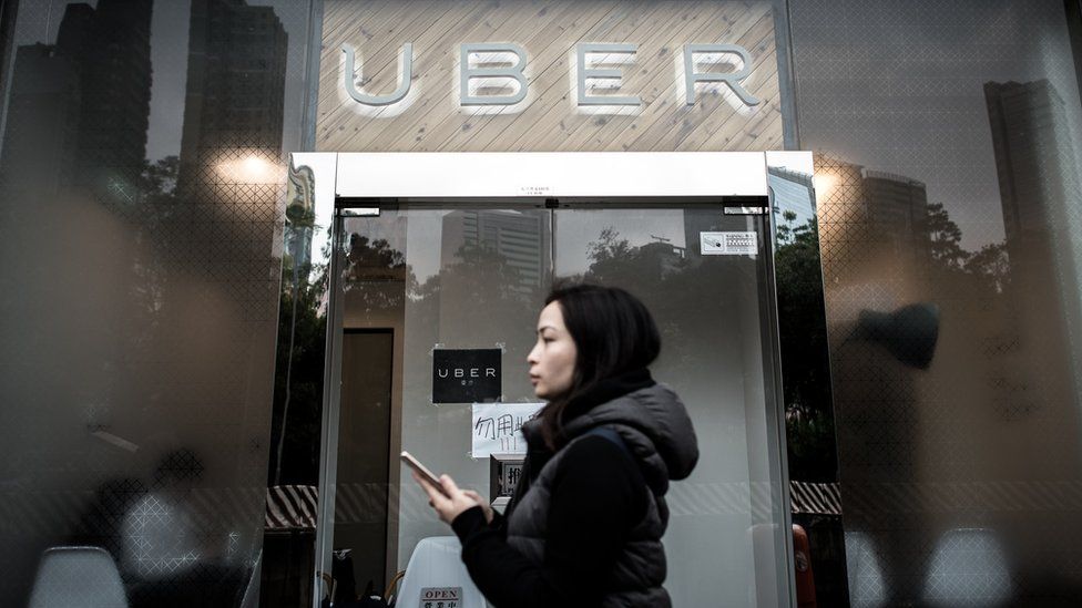 A woman walks past the Uber offices in Hong Kong on January 22, 2016.