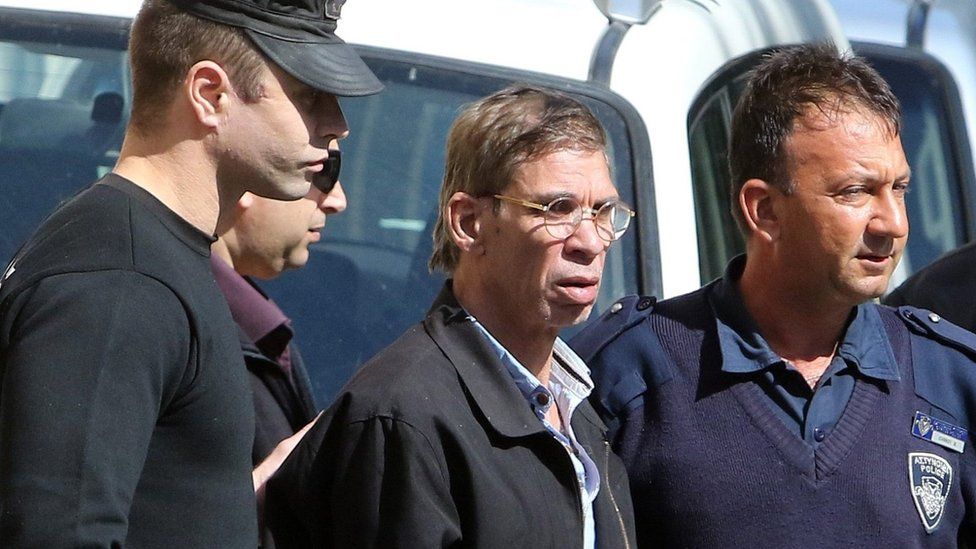 Seif Eldin Mustafa (C) flanked by Cypriot police as they leave a court in Larnaca.