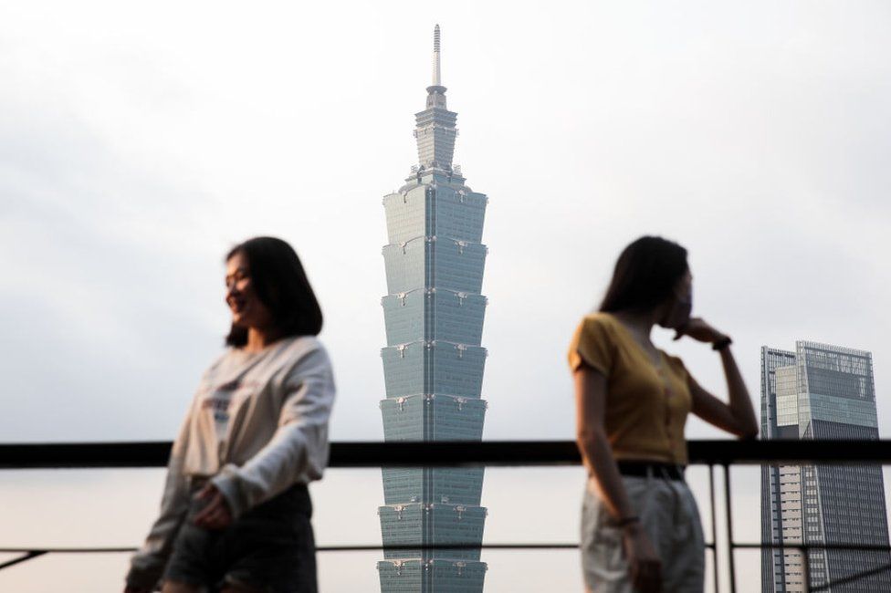 People pose for photographs in front of the Taipei 101 building in Taipei, Taiwan, on Tuesday, Jan. 26, 2021.