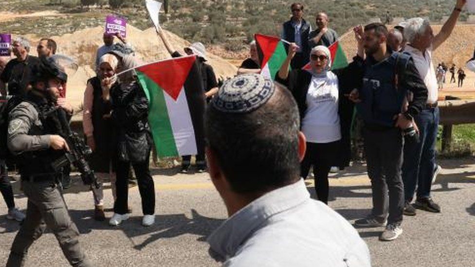 Palestinian protesters, Israeli soldier and settler at entrance of Hawara (03/03/23)