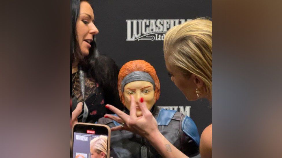 Ms Sackhoff fixing the cake's nose