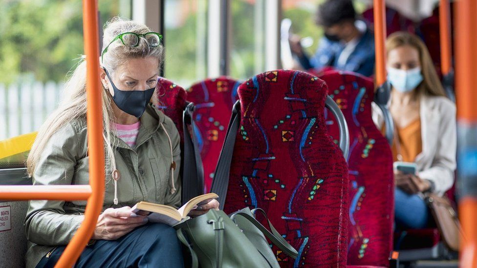 Woman sitting on a bus wearing a protective mask during the Covid-19 pandemic