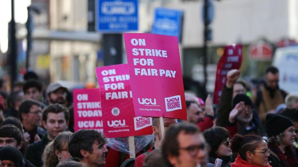 Члены Союза университетов и колледжей (UCU) маршируют во время второго дня забастовки по поводу заработной платы, условий труда и пенсий в Манчестере