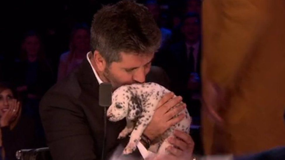 Simon Cowell kissing a puppy