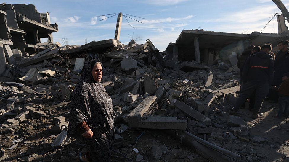 A Palestinian woman stands at the site of an Israeli strike on a house in Rafah