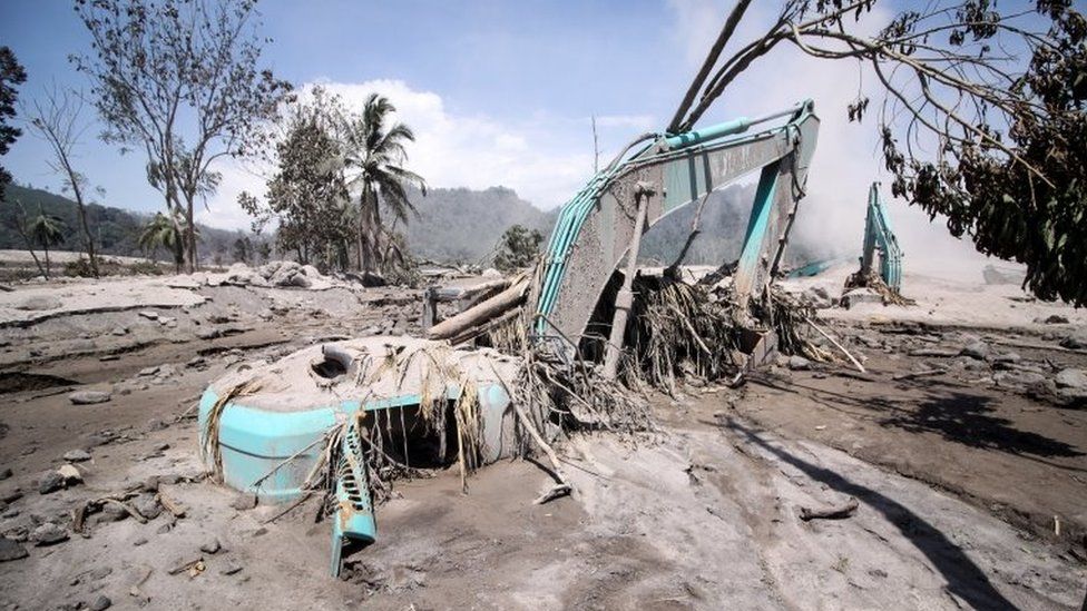 Excavators are seen covered in volcanic ash from the eruption of Mount Semeru volcano