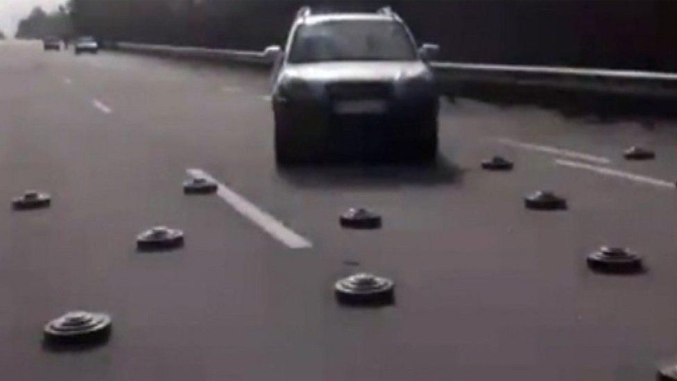 Cars drive around landmines on a Ukrainian road