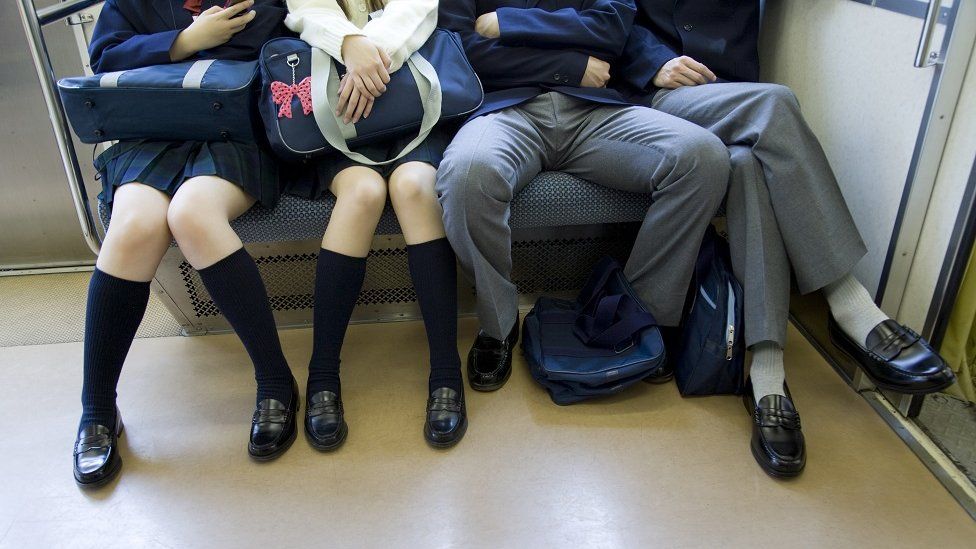 A man sitting between two others on a train