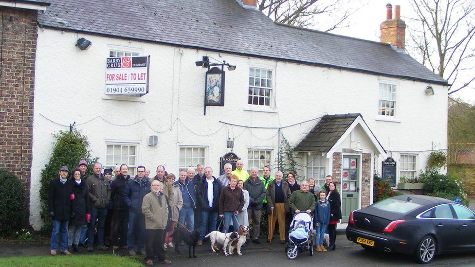 People standing in front of a pub
