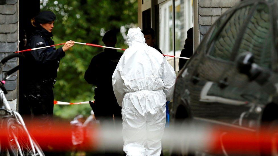 Police officers at the entrance of a residential building where the bodies of five children were found in the western town of Solingen, Germany