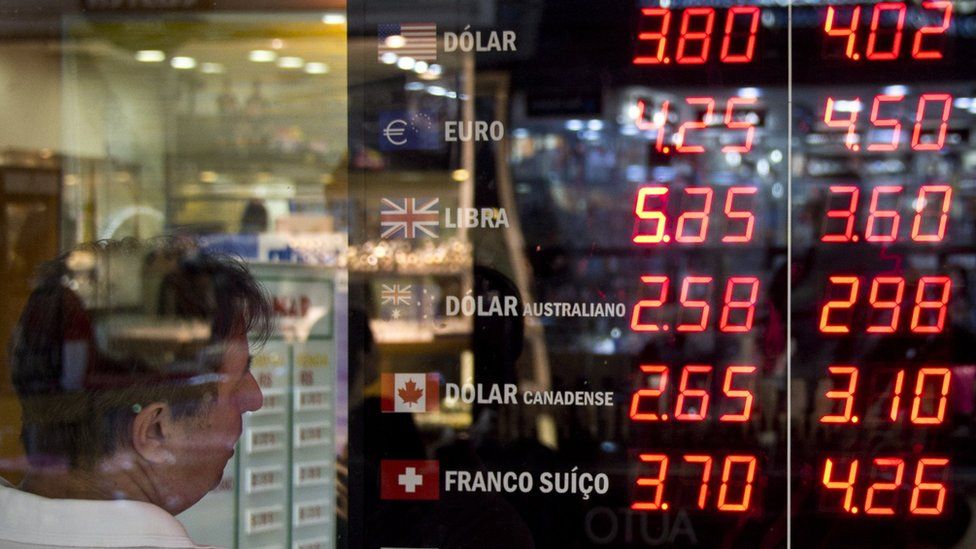 A man looks at the currencies board of a bureau de change in downtown Rio de Janeiro, Brazil, on September 10, 2015