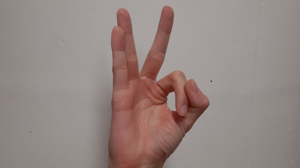 The "OK" hand gesture reversed looks like the number sequence "110"