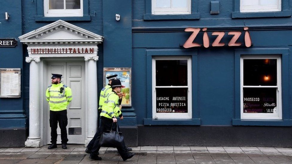 A police officer stands outside a restaurant which was closed after former Russian inteligence officer Sergei Skripal, and a woman were found unconscious on a bench nearby
