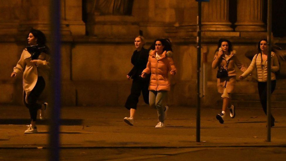Women run away from the first district near the state opera in central Vienna