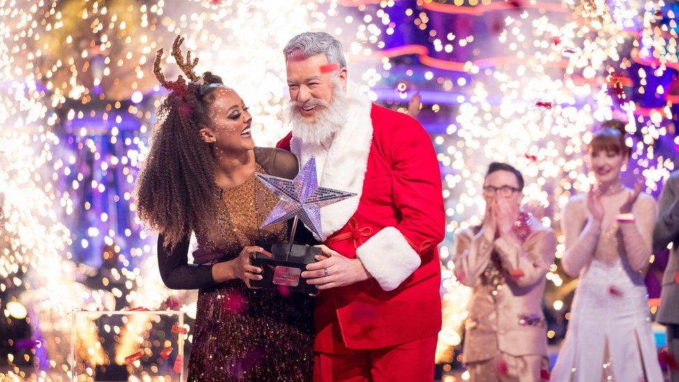 Александра Марделл и Кай Уиддрингтон держат трофей после победы в специальном рождественском выпуске «Танцы со звездами» 2022 года