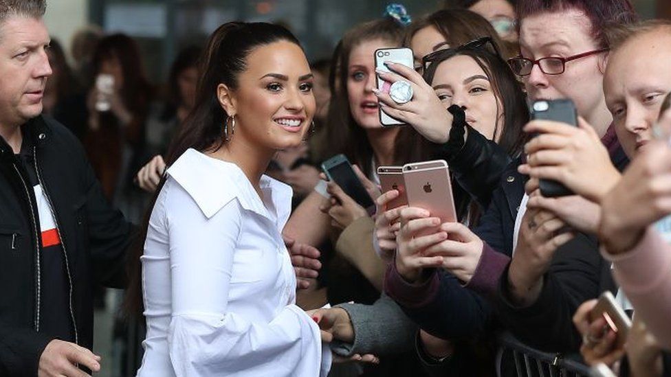 Demi Lovato poses with fans