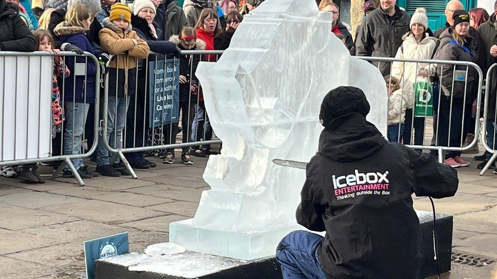 Man using a chainsaw to sculpt ice