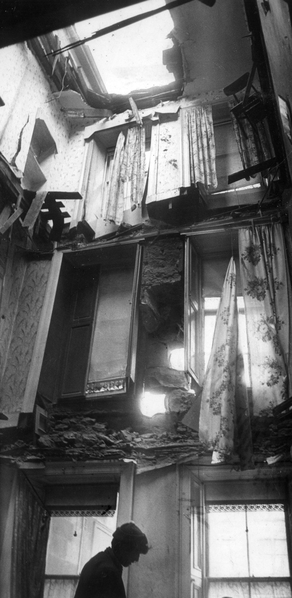 A workman inspects the damage inside a tenement building in Dumbarton Road.