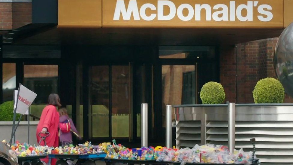 Ella and Caitlin McEwan at McDonald's headquarters with a trailer full of plastic Happy Meal Toys