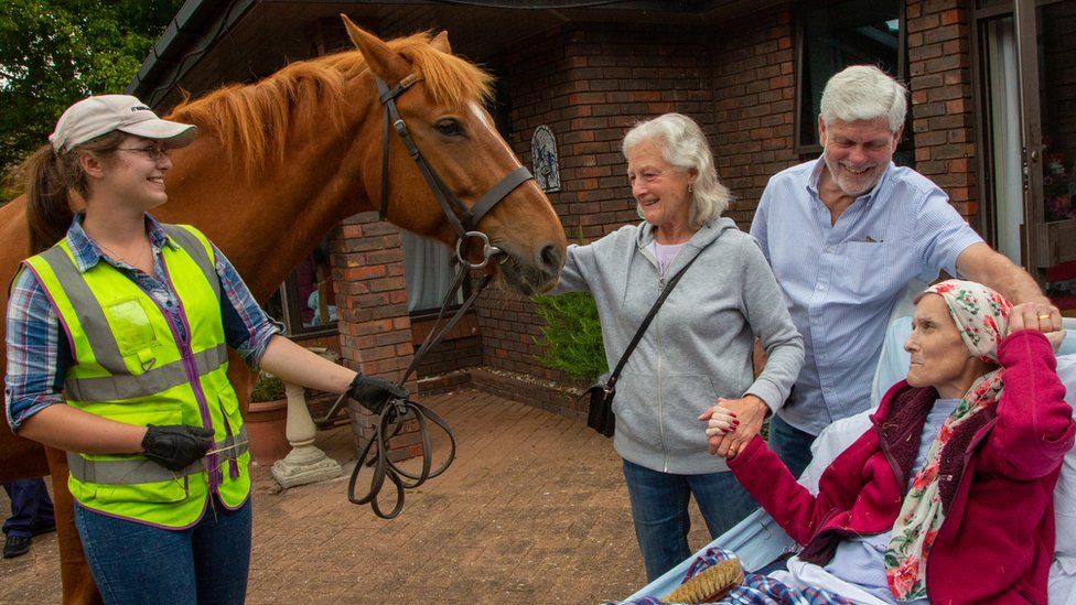 Hayley Golding with three other people with a horse outside a hospice