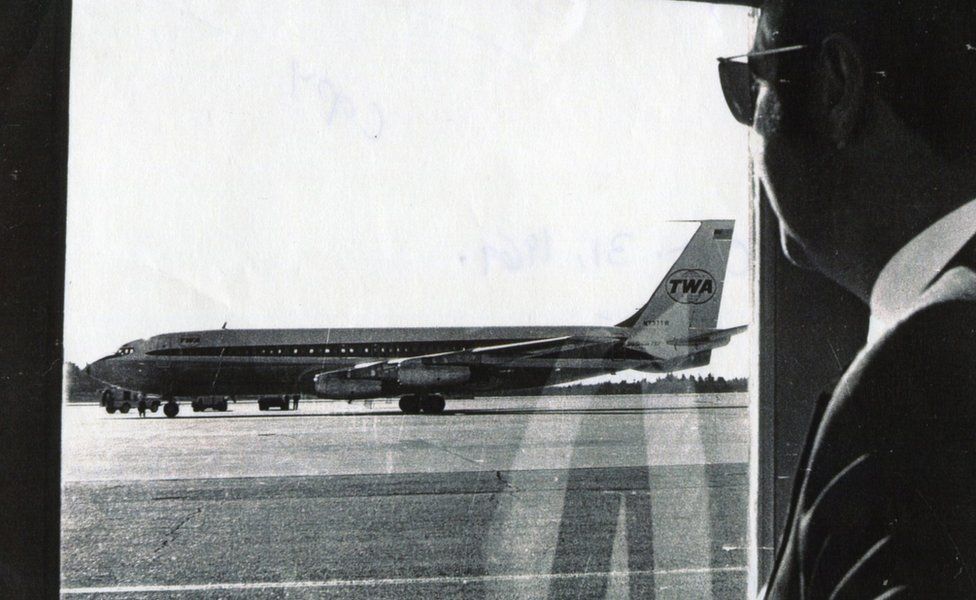 Airline official Norman Kaye looks out at hijacked TWA85 at Bangor airport, Maine