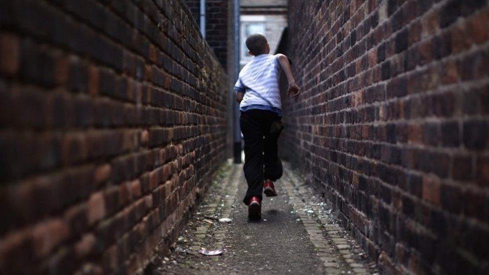 Child running through alley