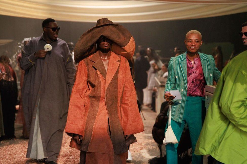 A models wearing Nigerian fashion designer Bubu Ogisi's design, walks down the runway during her fashion show in Lagos. The silhouettes are oversized and the materials used are of vibrant yet earthy tones.