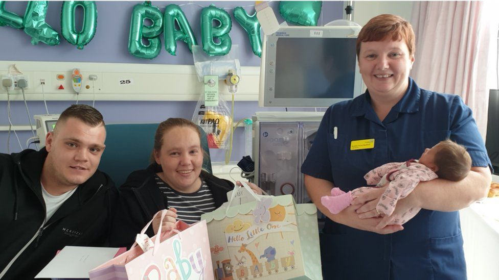 Ellie Pierce-Oliver with partner Dan Taylor and hospital staff