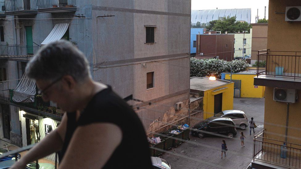 The dome being built to cover the mineral park in Taranto is seen from the balcony of a residential property in the Tamburi neighbourhood