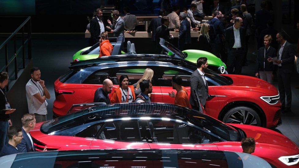 Visitors look at Volkswagen electric cars during the press days at the 2019 IAA Frankfurt Auto Show
