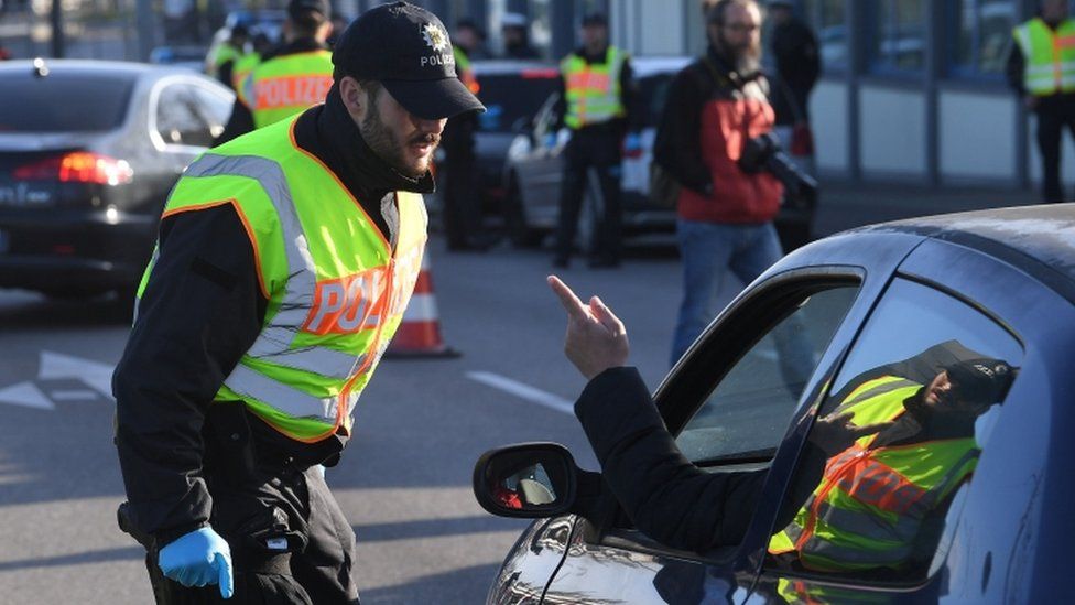 A German police officer controls a motorist at the French-German border between Kehl and Strasbourg