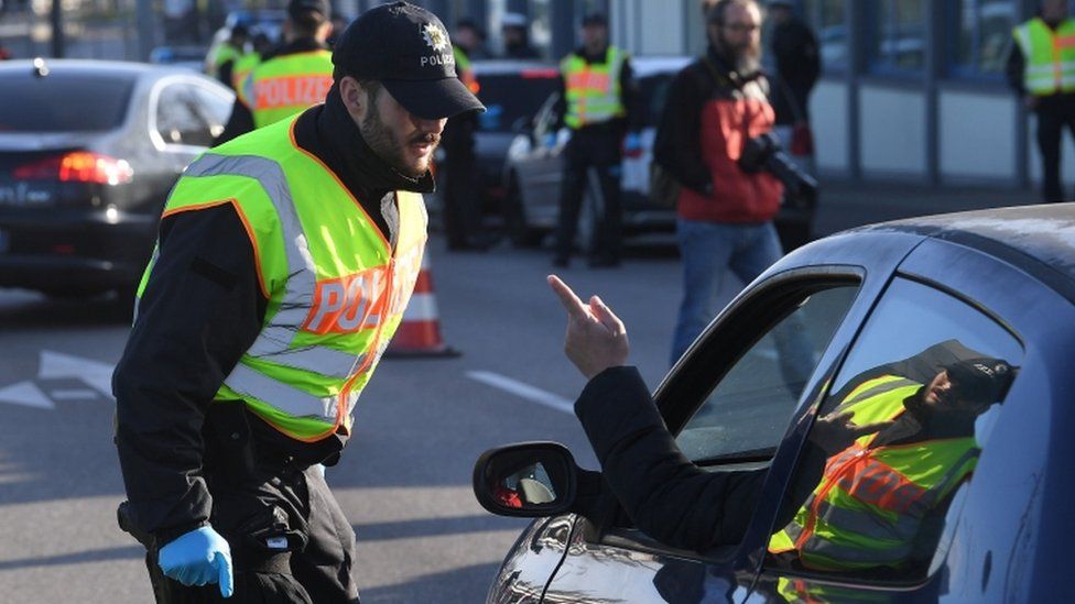 Weil Am Rhein, Germany. 16th Mar, 2020. An official of the Swiss border  guard is standing at the border crossing on the A5. In the coronavirus  crisis, Germany will introduce comprehensive controls