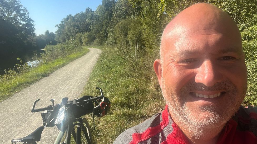 Mike Kelly takes a selfie in front of his bike in France